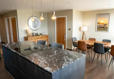 a kitchen and dining room with a marble counter top at Pendle View Sleeps 8 with Hot Tub in Longridge