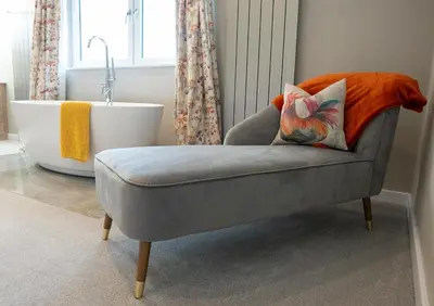 a gray chair with a pillow and a bath tub at Pendle View Sleeps 8 with Hot Tub in Longridge
