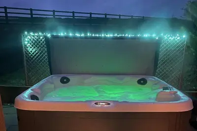 a bath tub with green liquid in it with lights at Pendle View Sleeps 8 with Hot Tub in Longridge