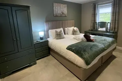 a bedroom with a large bed with a dresser and a bed sidx sidx sidx at Pendle View Sleeps 8 with Hot Tub in Longridge