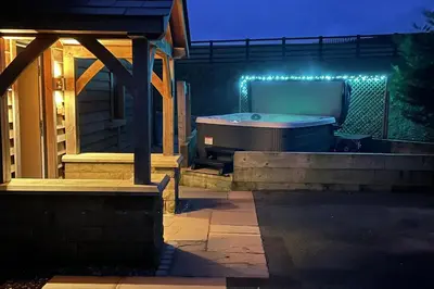 a hot tub on a patio at night at Pendle View Sleeps 8 with Hot Tub in Longridge
