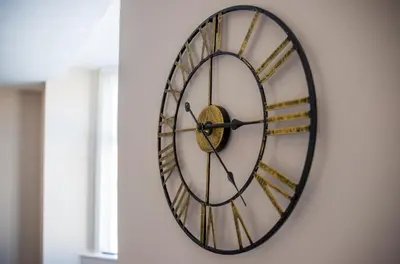 a clock is hanging on a wall at Withnell Stays - Apartment Two in Blackpool