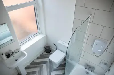 a bathroom with a toilet and a sink and a window at Withnell Stays - Apartment Two in Blackpool