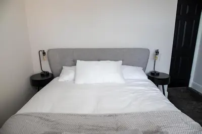 a bed with white sheets and pillows in a bedroom at Withnell Stays - Apartment Two in Blackpool