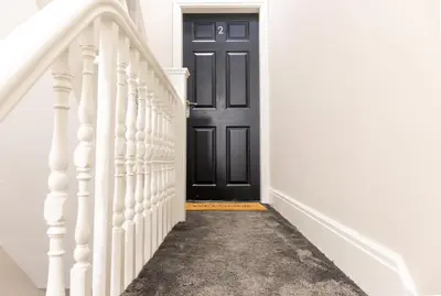 a black door on a white wall with a hallway at Withnell Stays - Apartment Two in Blackpool