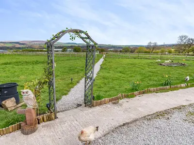 a gate to a field with a field of grass at Pendle View Lodge in Altham