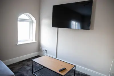 a living room with a coffee table and a flat screen tv at Withnell Stays - Apartment Three in Blackpool