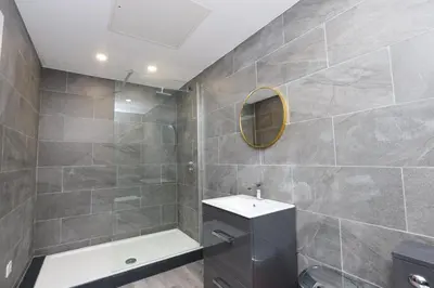 a bathroom with a shower and a sink and a mirror at Concert Square Apartments By Happy Days in Liverpool