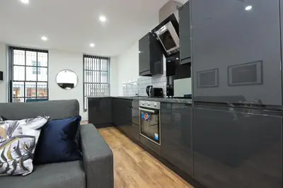 a living room with a couch and a kitchen at Concert Square Apartments By Happy Days in Liverpool
