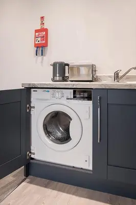 a washing machine in a kitchen with a counter at Cavern Quarter apartments by The Castle Collection in Liverpool