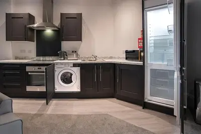 a kitchen with a washer and dryer in it at Cavern Quarter apartments by The Castle Collection in Liverpool
