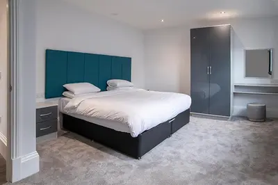a bedroom with a large bed with a green headboard at Cavern Quarter apartments by The Castle Collection in Liverpool