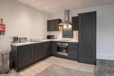 a kitchen with black cabinets and a sink at Cavern Quarter apartments by The Castle Collection in Liverpool