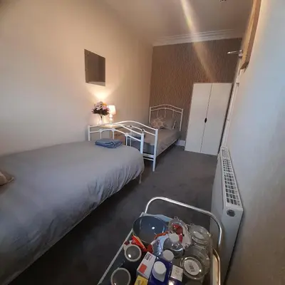 a hotel room with two beds and a tray of dishes at Merginn Guest House in Blackpool