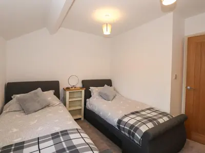 two beds sitting next to each other in a bedroom at 1 The Stables in Grange Over Sands