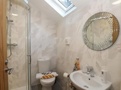 a bathroom with a toilet and a sink and a mirror at 1 The Stables in Grange Over Sands