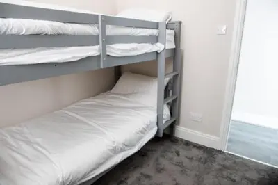 two bunk beds in a room with a white bed at Withnell Stays - Apartment One - Ground Floor - Retro Gaming Machine in Blackpool