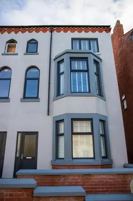a white house with black windows at Withnell Stays - Apartment One - Ground Floor - Retro Gaming Machine in Blackpool