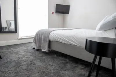 a bedroom with a bed and a table and a window at Withnell Stays - Apartment One - Ground Floor - Retro Gaming Machine in Blackpool