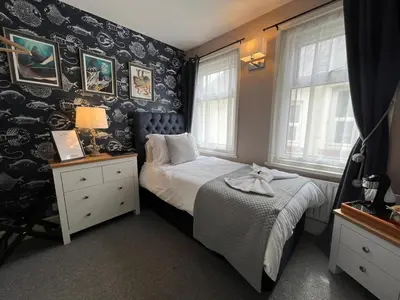a small bedroom with a bed and a window at McGraths Hotel & Public Bar in Blackpool