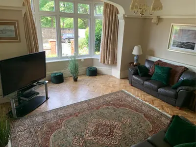 a living room with a couch and a flat screen tv at Entire Seaside Home, Sleeps 8, All en-suite rooms in New Brighton