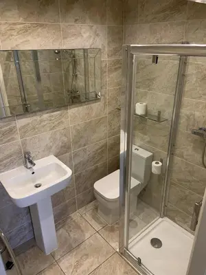 a bathroom with a sink and a toilet and a shower at Entire Seaside Home, Sleeps 8, All en-suite rooms in New Brighton