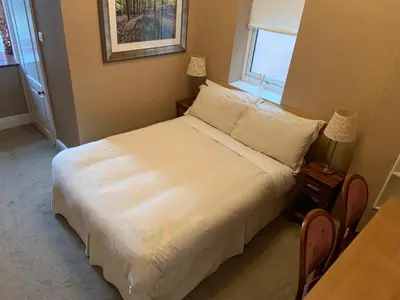 a bedroom with a large white bed with a window at Entire Seaside Home, Sleeps 8, All en-suite rooms in New Brighton