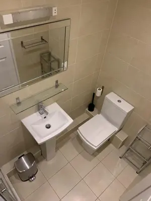 a bathroom with a toilet and a sink and a mirror at Entire Seaside Home, Sleeps 8, All en-suite rooms in New Brighton