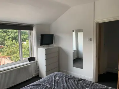 a bedroom with a bed and a tv and a mirror at House - Sleeps 5 - Pet friendly - Garden - Parking in Saint Annes on the Sea