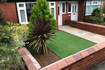 a garden with a palm tree in front of a house at House - Sleeps 5 - Pet friendly - Garden - Parking in Saint Annes on the Sea