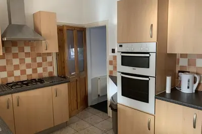 a kitchen with wooden cabinets and white appliances at House - Sleeps 5 - Pet friendly - Garden - Parking in Saint Annes on the Sea