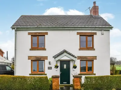 a white house with a green door at Hornby Cottage in Saint Michaels on Wyre