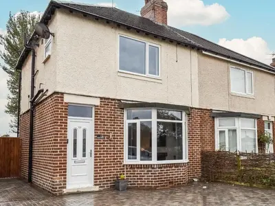 a brick house with a white door and windows at Excalibur Cottage in Saint Annes on the Sea