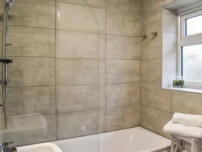 a bathroom with a shower and a bathtub at Excalibur Cottage in Saint Annes on the Sea