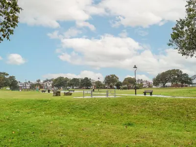 a park with a bench in the grass at Excalibur Cottage in Saint Annes on the Sea