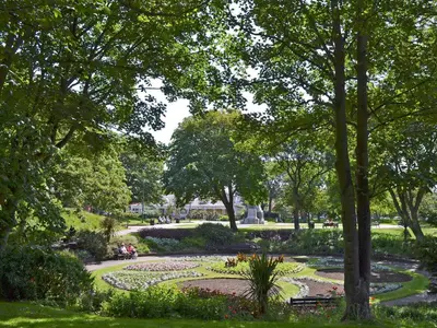 a park with a garden with flowers and trees at Excalibur Cottage in Saint Annes on the Sea