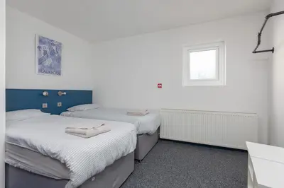 two beds in a room with a window at Blackpool Lodge Apartments in Blackpool