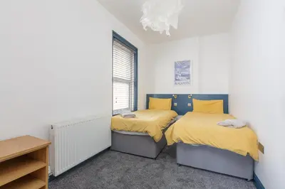 a bedroom with two beds and a window at Blackpool Lodge Apartments in Blackpool