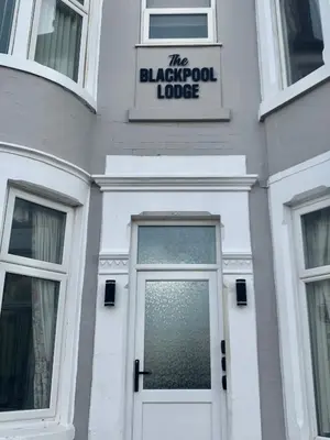 a white building with a door and a sign on it at Blackpool Lodge Apartments in Blackpool