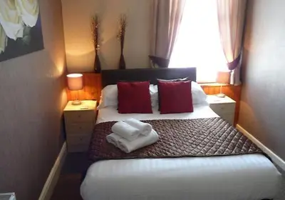a bedroom with a bed with two towels on it at the cumbrian hotel in Blackpool