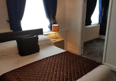 a bedroom with a bed and a window and a mirror at the cumbrian hotel in Blackpool