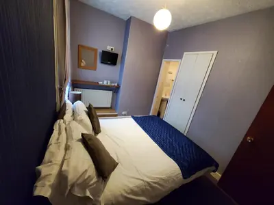 a bedroom with a large bed in a room at the cumbrian hotel in Blackpool