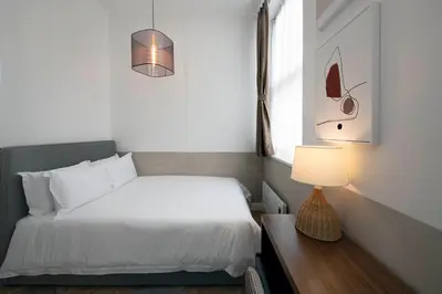 a bedroom with a bed and a table with a lamp at Trueman Court Luxury Serviced Apartments in Liverpool
