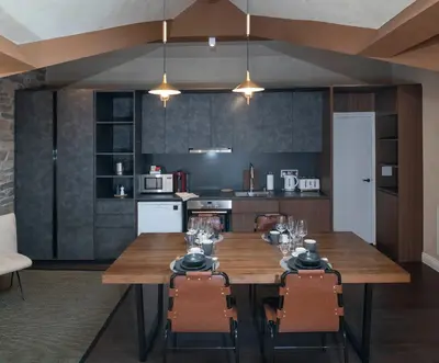a kitchen with a wooden table and chairs at Trueman Court Luxury Serviced Apartments in Liverpool