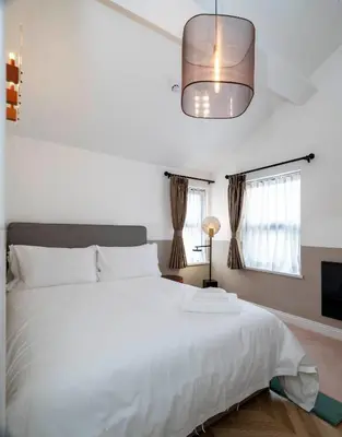 a bedroom with a white bed and a pendant light at Trueman Court Luxury Serviced Apartments in Liverpool