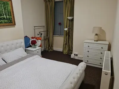 a bedroom with a white bed and a dresser and a window at Cheerful 4-bedroom holiday home close to the Sea in Blackpool