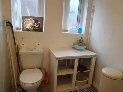 a small bathroom with a toilet and a sink at Litherland Apartment in Litherland