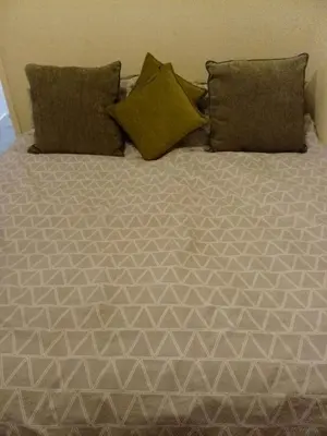 a bed with two pillows and a blanket on it at Litherland Apartment in Litherland