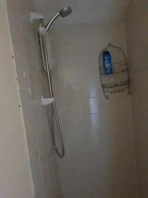 a shower with a shower head in a bathroom at Litherland Apartment in Litherland