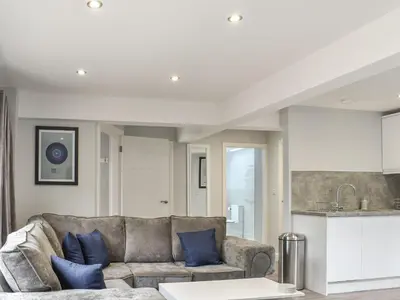 a living room with a couch and a kitchen at Woodgate Cottage in Dalton in Furness